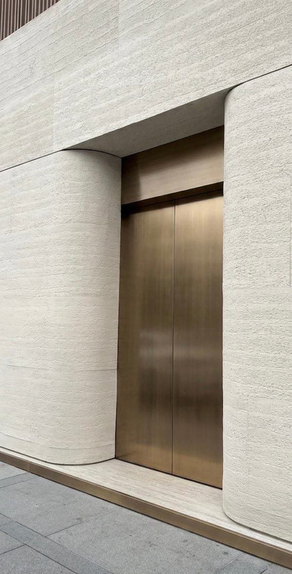 Moderná kancelária s ohybným obkladom AT-Europe na stĺpoch a pri výťahu, demonštrujúca čisté línie.